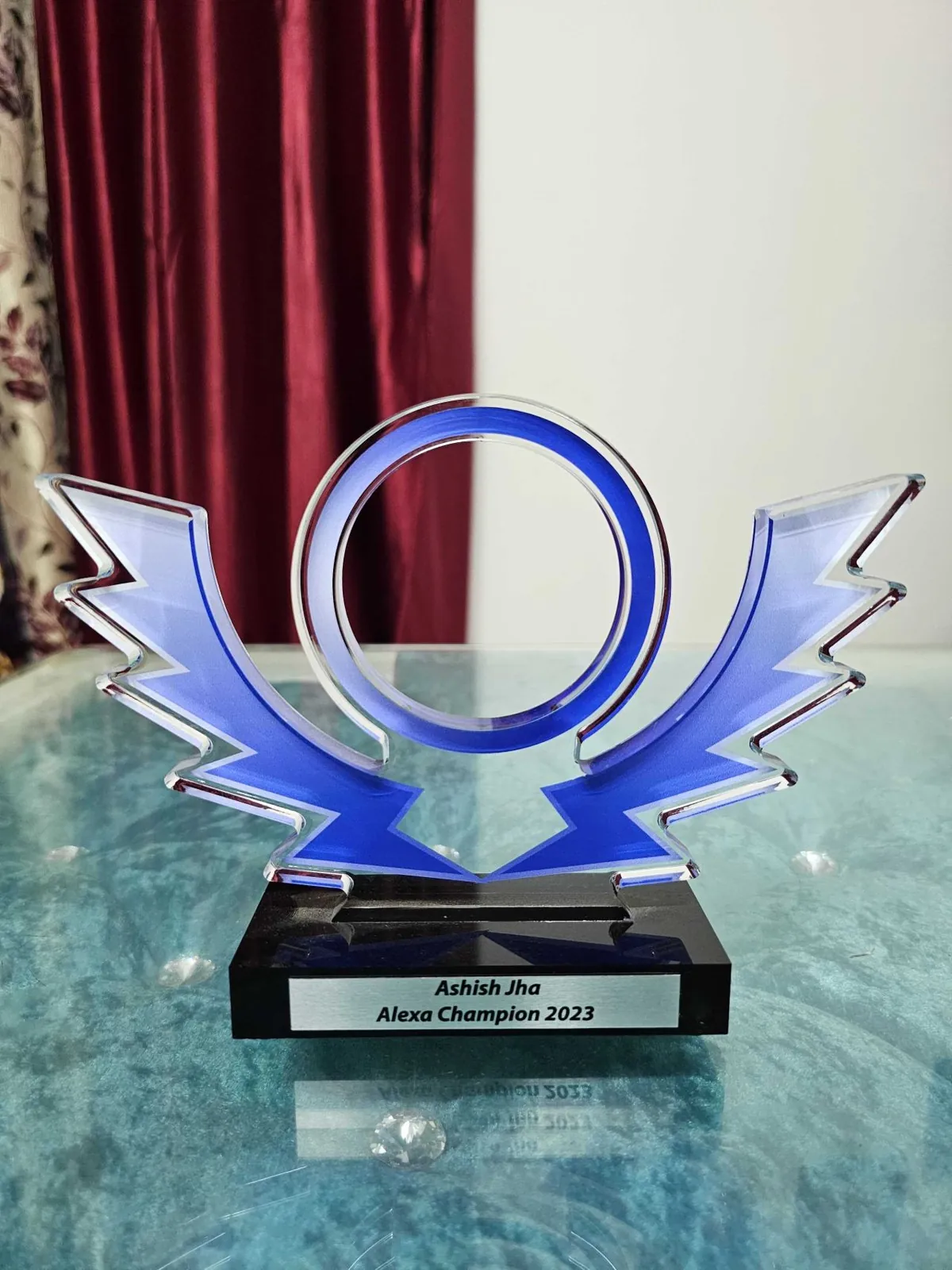 A blue Alexa trophy on a black base engraved Alexa Champion 2023.