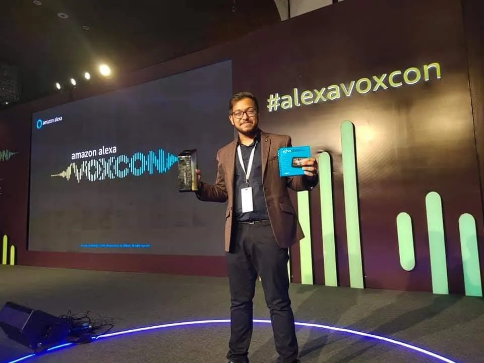 Ashish holding his community award and an Echo Show on the VOXCON stage.