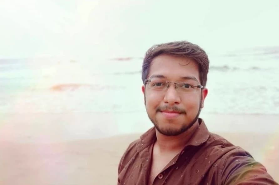 Ashish taking a selfie on a Mumbai beach, with the sea behind him.