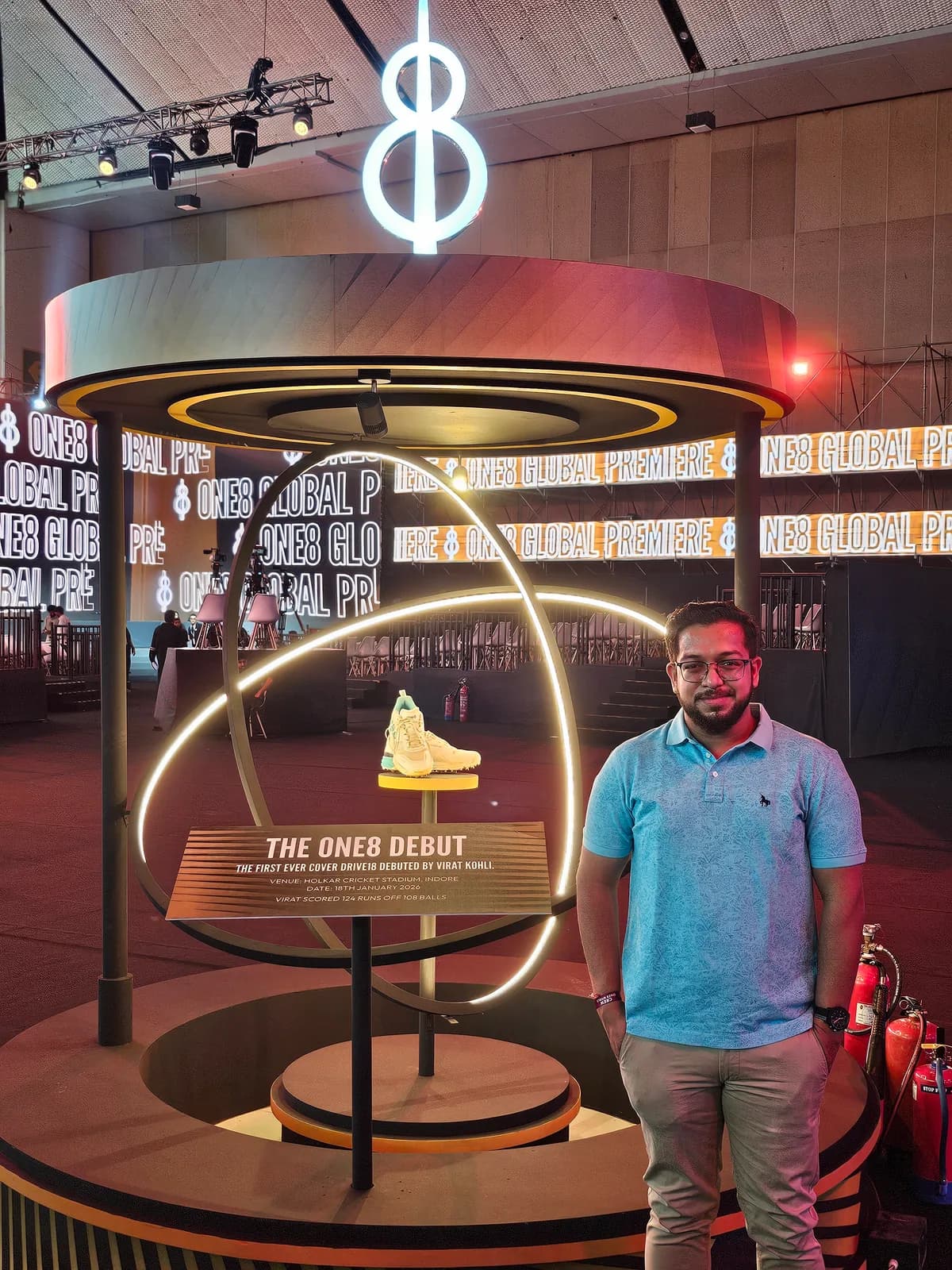 Ashish standing beside a shoe display at the one8 launch.