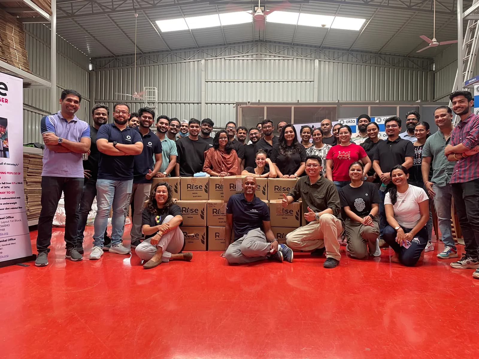 The Okta volunteering group gathered for a photograph in the Rise Against Hunger warehouse.